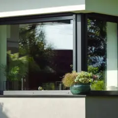 Nowoczesny parapet zewnętrzny z kamienia, ozdobiony doniczką z kwiatami. Zastanawiasz się, czym czyścić parapety zewnętrzne?