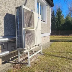 Pompa ciepła Panasonic zamontowana przy nowym domu. Instalacja zasilana dzięki dotacji, zapewnia ekologiczne ogrzewanie.