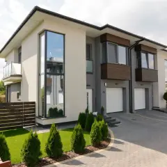 Nowoczesny dom z dużymi oknami antracyt. Wady? Może trudniejsze czyszczenie, ale efekt wizualny jest wart zachodu.