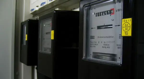 Liczniki przedpłatowe, jak doładować licznik? Na zdjęciu widać rząd czarnych liczników energii elektrycznej.