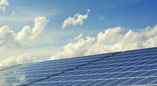 Łączenie paneli fotowoltaicznych pod błękitnym niebem z chmurami. Dioda w panelu to klucz do efektywnego przetwarzania energii słonecznej.