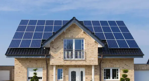Dom z panelami fotowoltaicznymi na dachu. Sprawdź aktualne fotowoltaika ceny i zainwestuj w zieloną energię.