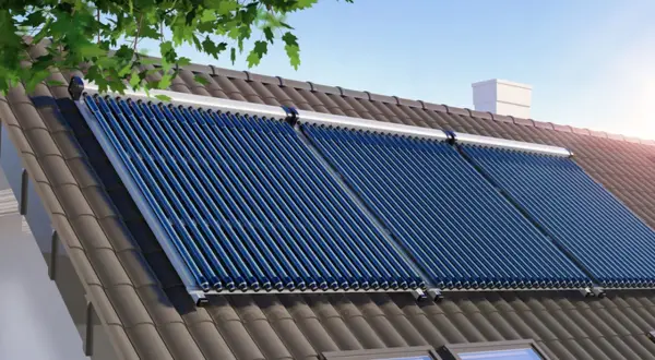 Kolektory słoneczne na dachu domu, idealne do pozyskania dofinansowanie do solarów na wodę.