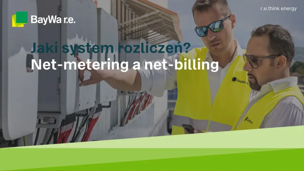 Dwóch mężczyzn w kamizelkach odblaskowych przy panelach fotowoltaicznych omawia systemy rozliczeń: net-metering a net-billing.
