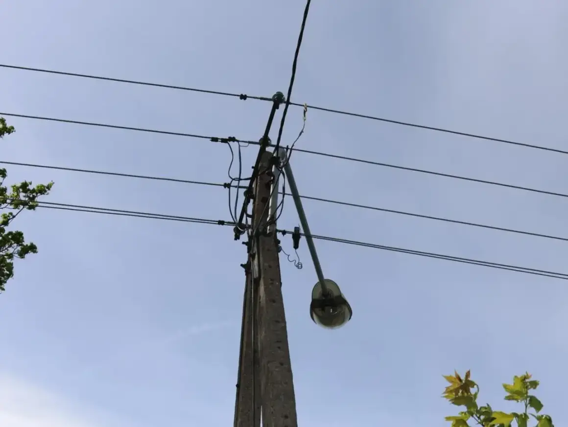 Słup energetyczny z wiszącą lampą uliczną, gdzie mogło dojść do kradzieży prądu. Policja bada sprawę.