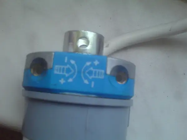 Element do regulacji krańcówek rolet z oznaczeniami kierunku i +/-.